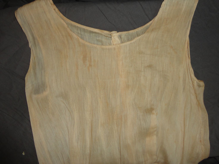 Brown acid-stains on a white 1920s wedding dress.