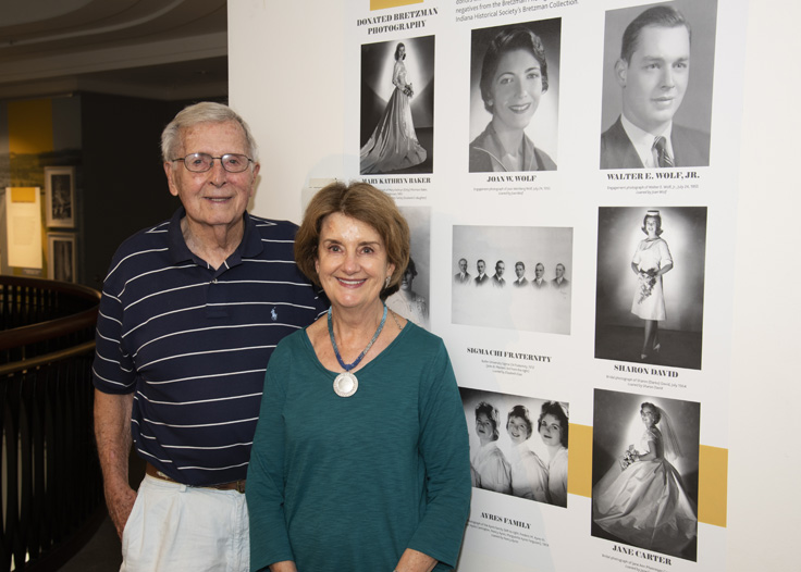 Jim Baker and daughter Debby stand in front of portraits in the Bretzman exhibit.